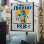 Ein großes Plakat kündigt das deutsch-polnische Schultheater-Festival „Fest“ 2026 an und zeigt eine bunte, stilisierte Gesichtsillustration. Daneben stehen weiße und goldene Luftballons sowie gestapelte Kartons mit der Jahreszahl 2026 in einem hellen Innenraum.