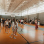 In einer hellen Sporthalle stehen und gehen viele junge Menschen in lockerer Kleidung und Socken auf dem orangefarbenen Hallenboden. An den Wänden sind Bänke, Sportgeräte und ein Basketballkorb zu sehen, während die Gruppe offenbar an einer gemeinsamen Übung oder Probe teilnimmt.